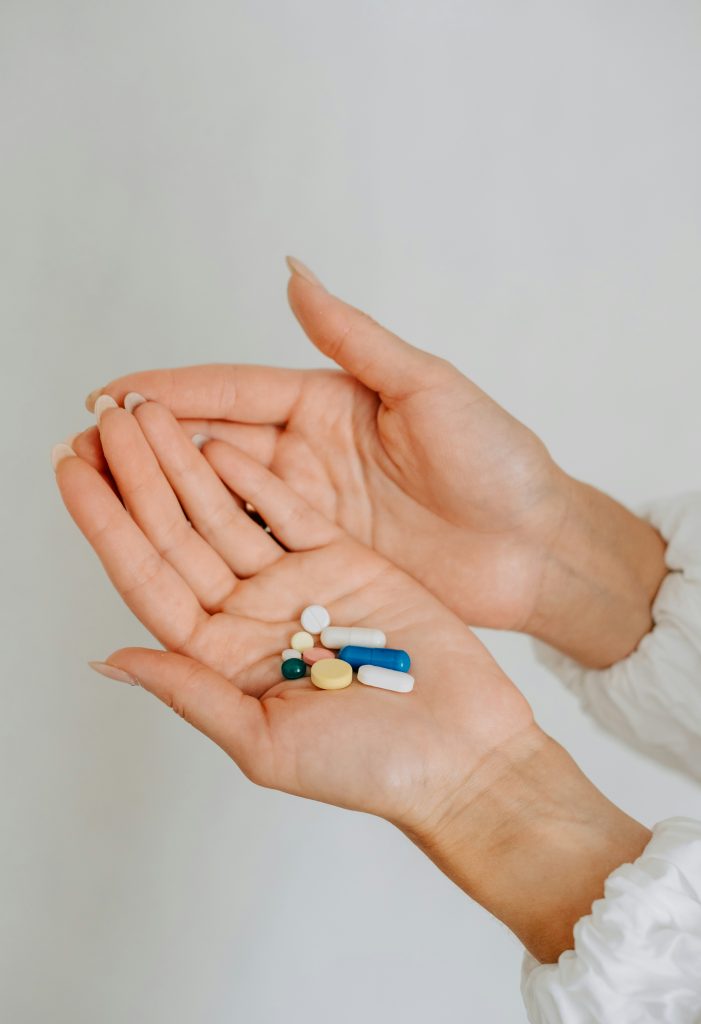 twee handen met daarin capsules